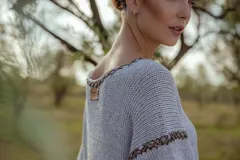 Minivestido tejido en lurex plateado, con escote en V y mangas cortas. Presenta detalle de bordado en el escote y mangas.