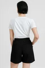 Short de lino de tiro alto, corte ancho y largo hasta la mitad del muslo, con estampado de rayas verticales blancas y azul oscuro.