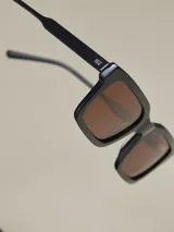 Lentes de sol cuadrados con montura gruesa color marrón y lentes polarizadas color negro. Marca Benson & Thomas, modelo Ian.