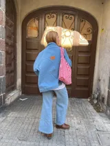 Campera de jean celeste de corte clásico, con cuello camisero, cierre frontal con botones metálicos y bolsillos en el pecho.