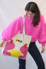 Bolso tipo tote de lona color crudo con asas de tela. Estampado con el logo 'picú' y diseño abstracto en colores amarillo, verde y fucsia.
