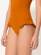 Traje de baño entero color azul marino con escote recto y breteles desmontables. Presenta volados en la cadera.