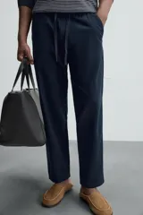 Pantalón azul marino de corte recto, con cintura elástica ajustable con cordón, bolsillos laterales y traseros.