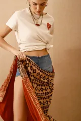 Pareo toalla rectangular de algodón con estampado étnico en tonos naranja, marrón y beige.