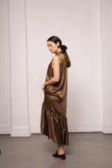 Vestido largo y amplio con cuello alto y mangas cortas abullonadas. Diseño a rayas verticales en tonos dorado y gris. Incluye viso liso al tono.