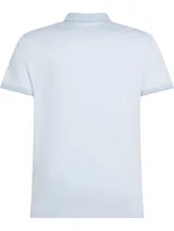 Chomba celeste de algodón con cuello clásico, tapeta de tres botones y logo de Tommy Hilfiger bordado en el pecho. Corte regular.
