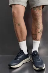 Zapatilla deportiva azul marino con capellada de tejido de punto transpirable, ajuste con cordones, plantilla OrthoLite® extraíble y suela con tecnología Spume Foam V2.