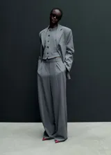 Pantalón de vestir gris con raya diplomática, tiro medio, corte recto y pinzas.