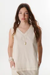 Top sin mangas confeccionado en mezcla de lino y algodón color marrón, con escote en V y pespuntes blancos decorativos en contraste.