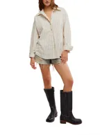 Camisa a rayas verticales color crema y marrón, de corte oversize y estilo masculino. Tiene cuello camisero, cierre frontal con botones y canesú en la espalda.
