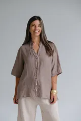 Camisa color visón de lino italiano, con cuello mao, manga corta y cierre frontal con botones.