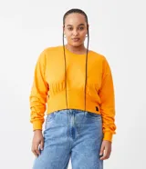 Sweater naranja de algodón, con cuello redondo, mangas largas y ribete elástico en la cintura.