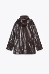 Parka marrón brillante con cuello alto y capucha oculta con cremallera metálica. Manga larga ajustable con cinta y botones a presión. Bolsillos delanteros con cremallera metálica. Cintura ajustable. Cierre frontal con cremallera y botones a presión.