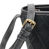 Bandolera negra de poliéster con diseño tejido formando rombos. Tiene acceso con cierre, correa regulable, herrajes color bronce, un compartimento principal, un bolsillo interno con cierre y otro abierto. El logo de XL Extra Large está al frente en símil cuero.