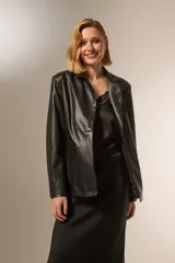 Blazer negro de eco-cuero, con cuello solapa, bolsillos frontales y cierre con botón.