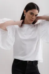 Blusa blanca de algodón con mangas largas abullonadas de gasa y puños elásticos.