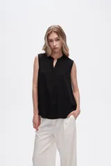 Blusa viscosa color negro, corte evasé, sin mangas, con cuello a la base y botón en la parte superior.