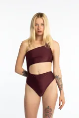 Malla enteriza color borgoña, asimétrica con un solo hombro y abertura en la cintura.