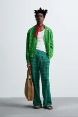 Pantalón relaxed fit de punto ligero tejido en hilatura con algodón, color verde con diseño a cuadros. Cintura elástica ajustable con cordón y bolsillos laterales.