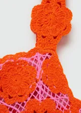 Vestido corto de crochet con diseño de flores color naranja sobre forro rosa, de tirantes anchos y escote cuadrado.