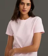 Remera tipo t-shirt de algodón, color beige claro, con cuello redondo y mangas cortas dobladas.