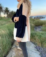 Polerón de terciopelo con diseño bicolor, con cuello alto y mangas largas.