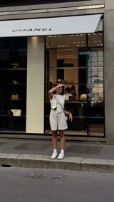 Blusa blanca con lunares negros, cruzada y atada en la cintura. Sin mangas y con cuello en V.