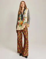 Blusa de manga larga con cuello tipo camisa y abertura frontal. Destaca por su combinación de estampas que aportan un toque artístico.