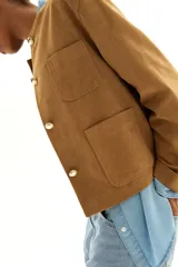Chaqueta color camel con cuello redondo, botones dorados y bolsillos parche delanteros.