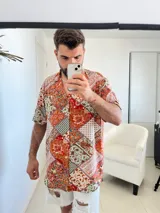 Camisa de manga corta con estampado de mosaicos en tonos naranja, rojo, blanco y negro.