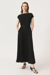 Vestido largo negro de tejido fluido, con cuello redondo y mangas cortas con dobladillo.