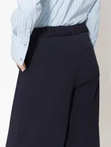 Pantalón de poplin 4way color azul marino, de corte wide leg, con lazo y elástico en la cintura, hebillas de enganche personalizados, presillas en la cintura, cierre a tono, gancho pantalonero, botón interno teñido a tono de tela, aberturas laterales inferiores, bolsillos laterales y bolsillos ojales en espalda.