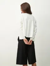 Camisa blanca de mangas largas y corte holgado.