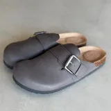 Zuecos grises con hebilla metálica ajustable y plantilla anatómica de corcho.