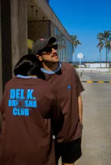 Remerón unisex de algodón color chocolate con cuello redondo celeste y estampado frontal y trasero celeste con logo de la marca.