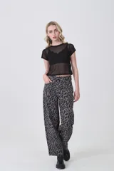 Remera de manga corta, cuello redondo y corte ajustado al cuerpo, confeccionada en tejido de poliéster con estampado de camuflaje en tonos verde militar, beige y marrón.