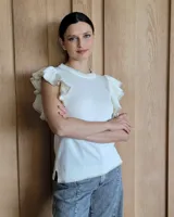 Musculosa blanca de punto con cuello redondo y mangas con volados.