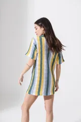 Vestido corto tejido calado a rayas horizontales en tonos naranja, amarillo y blanco, con cuello tipo polo y cierre frontal con botones.