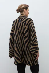 Ruana de punto jacquard con estampado animal print de cebra en colores negro y tostado, de diseño abierto y corte holgado.