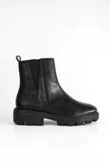Bota Chelsea negra de cuero con elásticos laterales, suela track y tirador trasero.