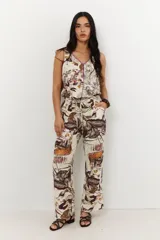 Pantalón de vestir con estampado botánico en tonos marrones y naranjas.