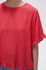Blusa color coral con cuello redondo y mangas cortas con volados.