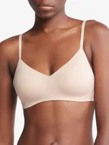 Corpiño Calvin Klein color piel, ligeramente forrado, sin aros, con breteles finos con logo de la marca y escote en V.