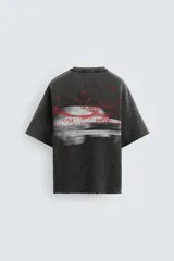 Camiseta negra con efecto lavado, corte boxy fit, cuello redondo y manga corta. Estampado rojo en el frente.