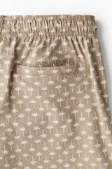 Short de baño color marrón con estampado de palmeras, con cintura elástica ajustable con cordón, bolsillos laterales y trasero con cierre autoadherente.