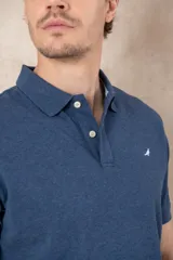 Chomba azul marino de piqué con cuello clásico, tapeta de dos botones y logo de pájaro bordado en color rosa en el pecho.