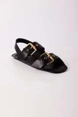 Sandalias negras de cuero con dos tiras anchas sobre el empeine, hebillas doradas y tira trasera.