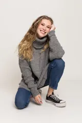 Sweater gris de lana merino con cuello alto y bolsillos delanteros.