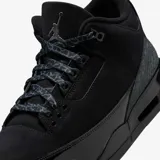 Zapatilla deportiva de caña media Air Jordan 3 Retro, completamente negra (colorway 'Black Cat'). Presenta una construcción en nubuck o gamuza negra, con detalles en charol negro brillante en el guardabarro y patrones texturizados (posiblemente efecto piel de elefante) en negro tonal en el guardabarro delantero y el talón. Incorpora el logo Jumpman en la lengüeta y una unidad de aire visible en el talón.