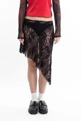 Pollera corta de encaje negro, con diseño asimétrico e irregular en el ruedo.